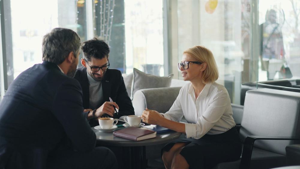 Three professionals in a meeting at a coffee table