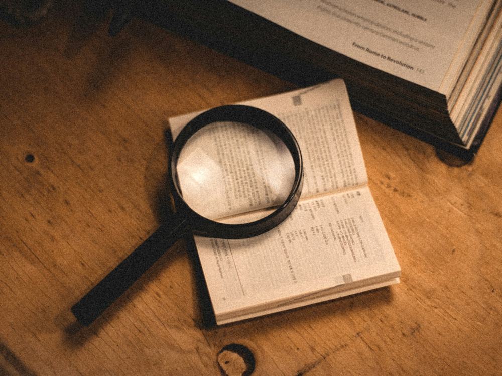 A magnifying glass resting on an open register