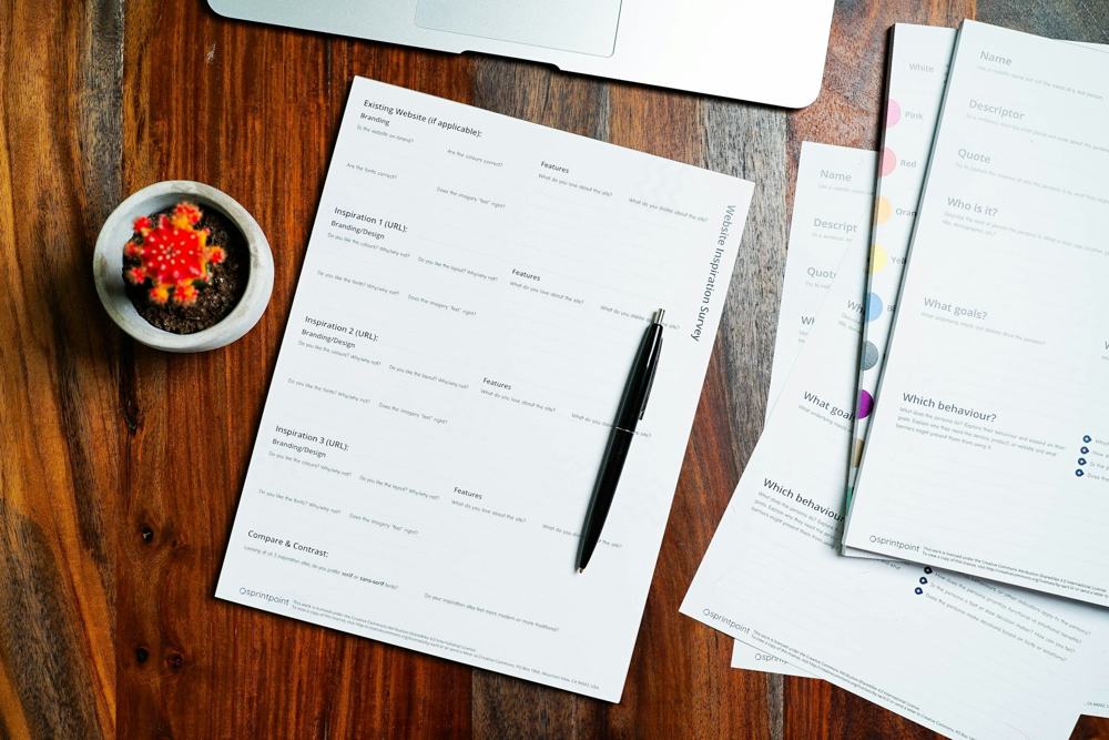 Forms and a pen on a wooden desk